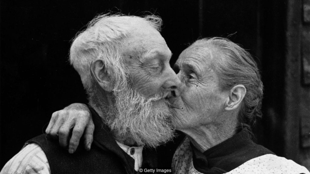 Casal idoso se beijando.
