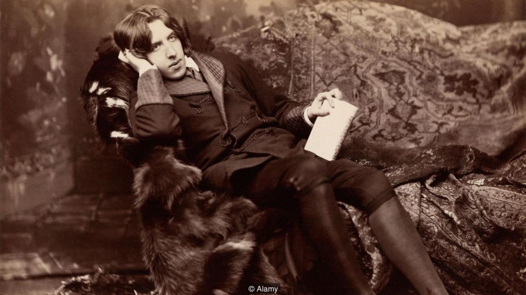 Oscar Wilde reclinado num sofá.